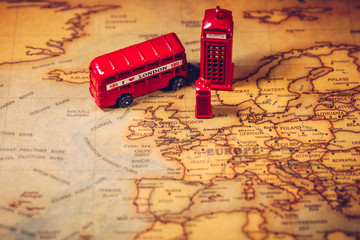 The iconic red bus and Big Ben miniature with compass on the map of London, UK. Concept of travel....