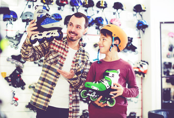 Seller assisting boy in choosing roller-skates