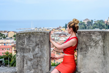 Fototapeta na wymiar Girl in red in Santa Margherita, Italy. Beautyful vity view and mountains backgrounds
