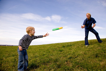 Boy and father play frisbee
