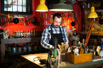 Smiling male worker working on belt leather