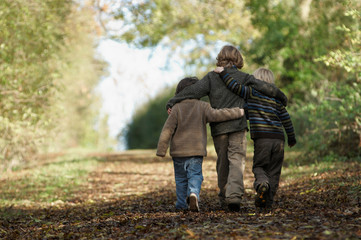 Three boys walking up country lane
