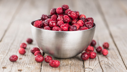 Old wooden table with fresh Dried Cranberries (close-up shot; selective focus)