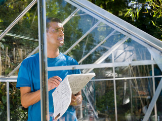 Man building greenhouse in garden