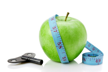 green apple and blue measure tape with clue isolated on white background