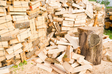 Logs in a metal grid cage with a chopping block on a lumber yard