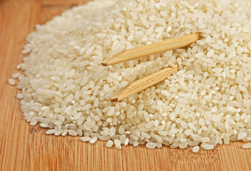 raw rice and chopsticks on bamboo board