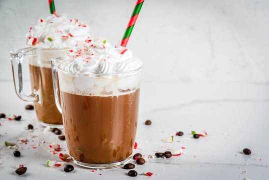 Homemade Peppermint Mocha, Christmas coffee drink with candy canes, whipped cream and mint syrup , on white marble table, copy space