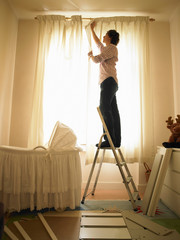 Man hanging curtains
