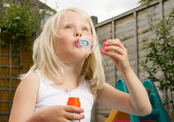 young girl having fun blowing bubbles