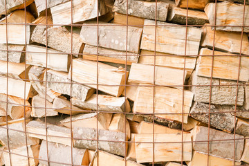 Close up of logs in a metal grid cage with a chopping block on a lumber yard