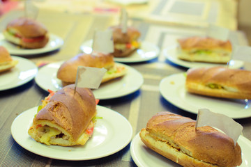 hot sandwich made by a child on a white plate with a sign
