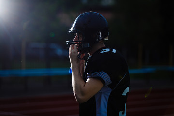  boy taking his football helmet off after a game