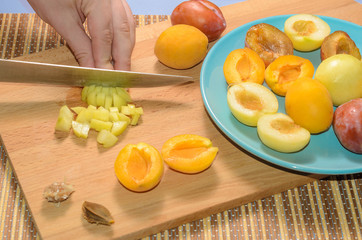 Hand cuts fruit on a wooden board