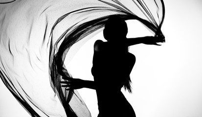 Silhouette of woman dancing with transparent fabric in black and white