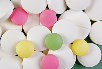 Pills and tablets on a green background