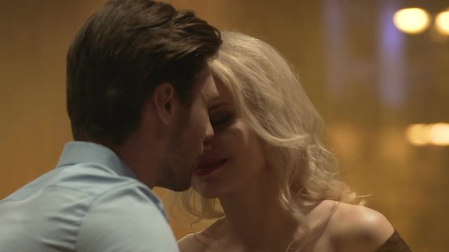 Young male and female sitting in bar and nuzzling, romantic date, infatuation