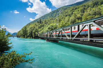 Europe train in Interlaken town with Thunersee river, Switzerland - obrazy, fototapety, plakaty