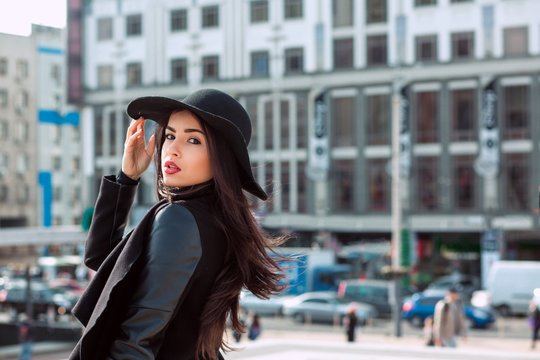 Outdoor closeup portrait of woman in fashionable black coat and stylish hat.Female fashion concept