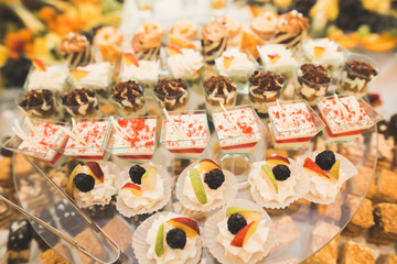Delicious sweets on wedding candy buffet with desserts, cupcakes