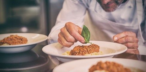 Closeup of a male chef garnishing food