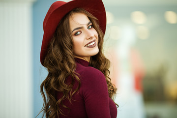Portrait of beautiful smiling elegant woman is wearing fashion autumn red clothes and hat infront...