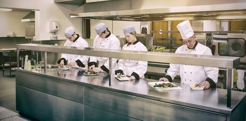 Chefs preparing plates in kitchen