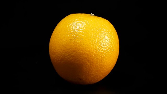 Healthy oranges spinning against black background