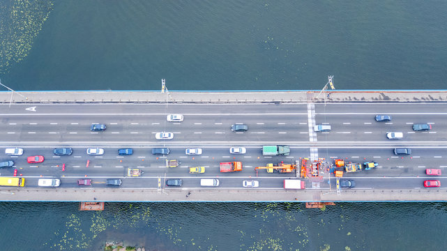Aerial top view of bridge road automobile traffic jam of many cars from above, block and road repair, city transportation concept
