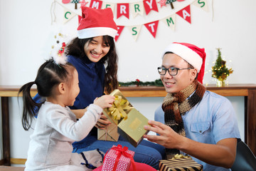 Asian family opening gift box in happiness moment on couch at home.