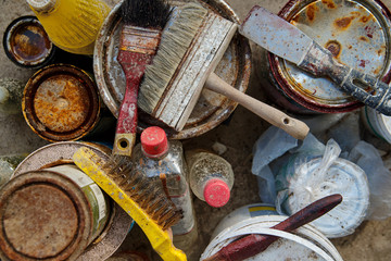 Dirty building tools on cans with paints
