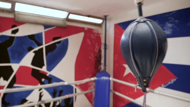 Boxer with bandage training on a floor to ceiling ball in the gym. Slow motion shot.