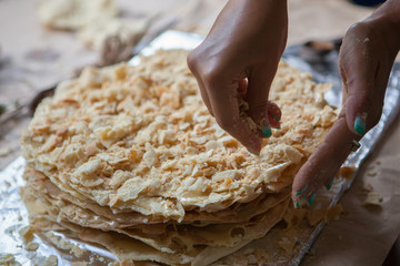 Hands strewing cake with crumbs