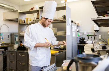 chef with clipboard doing inventory at kitchen