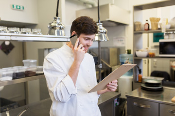 chef cook calling on smartphone at restaurant kitchen