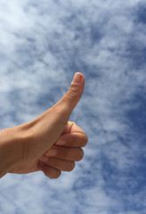 hand doing OK sign against blue sky