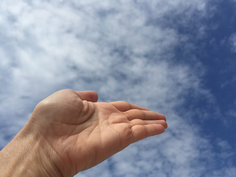 Empty open hand /palm against blue sky