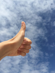 hand doing OK sign against blue sky