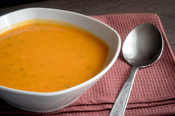 Pumpkin soup on brown background