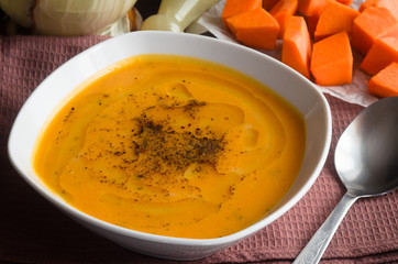 Pumpkin soup on brown background