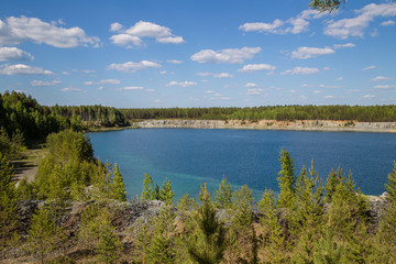 Fototapeta na wymiar Abandoned flooded open pit quarry mine abestos ore with blue water
