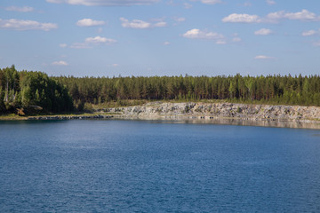 Abandoned flooded open pit quarry mine abestos ore with blue water