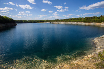Abandoned flooded open pit quarry mine abestos ore with blue water