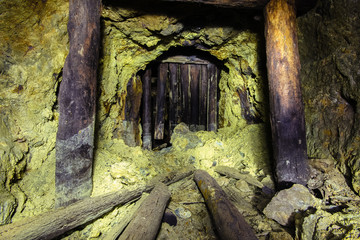 Fototapeta na wymiar Underground abandoned ore mine shaft tunnel gallery passage with wooden timbering