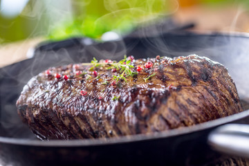 Beef steak. Juicy Rib Eye steak in pan on wooden board with herb and pepper