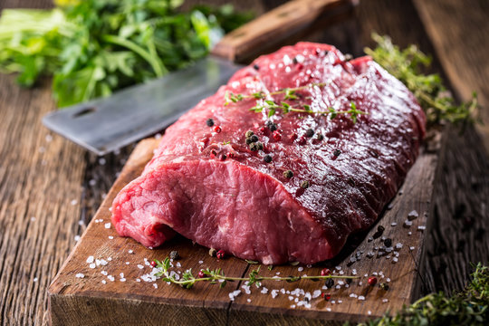 Beef Steak. Raw beef steak. Big Rib Eye steak on wooden board with herb salt and pepper.