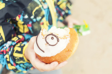 A boy on a walk eats a cake, a smiley face,