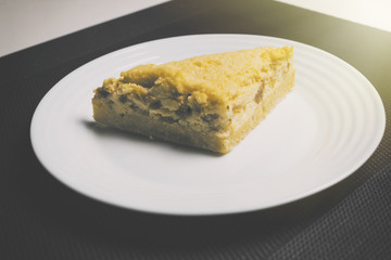 Peach pie on black and white background with sunlight from side. Yellow Peach pie on the table in kitchen. Peach pie with apricot.