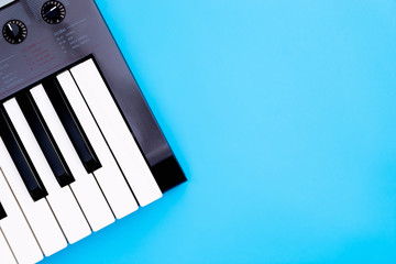 Fototapeta na wymiar Music keyboard synthesizer instrument on blue copy space for Music poster concept