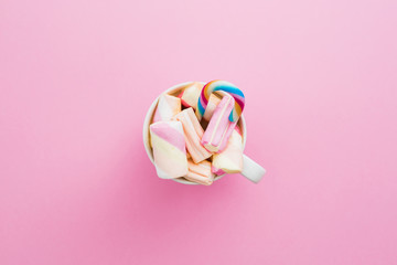 Marshmallow with cappuccino mug and cane sugar on pink background. Flat lay, top view
